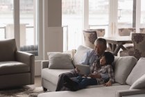 Großvater und Enkelin mit digitalem Tablet auf Sofa im heimischen Wohnzimmer — Stockfoto