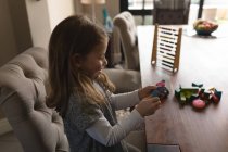 Cute girl playing with toys at home — Stock Photo