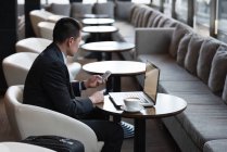 Бизнесмен с помощью мобильного телефона на диване в отеле — стоковое фото