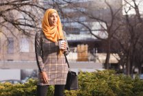 Hijab mujer tomando café en el parque - foto de stock
