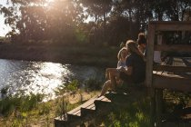 Група друзів розмовляють один з одним на каюті біля озера — стокове фото