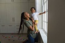 Madre e figlio giocare vicino alla finestra a casa — Foto stock