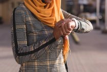 Hijab mujer usando reloj inteligente en la ciudad - foto de stock