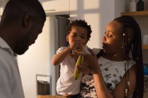 Mère nourrir son fils dans la cuisine à la maison — Photo de stock