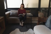 Bella dirigente donna che legge un libro in ufficio — Foto stock
