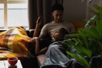 Пара використовує мобільний телефон на дивані у вітальні вдома — стокове фото