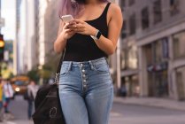 Женщина среднего звена с помощью мобильного телефона в городе — стоковое фото