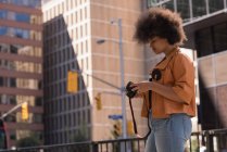 Frau überprüft Fotos vor der Kamera in der Stadt — Stockfoto