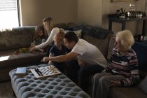 Семья из нескольких поколений играет в игры на диване в гостиной дома — стоковое фото