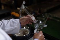 Крупним планом працівник досліджує склопродукт на скляній фабриці — стокове фото