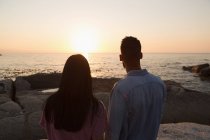 Rear view of couple standing near sea side on a sunny day — Stock Photo