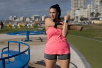 Bella jogger femminile che si estende nel parco — Foto stock