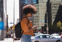 Frau benutzt Handy an einem sonnigen Tag in der Stadt — Stockfoto