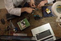 Vista ad alto angolo degli ingegneri robotici che assemblano circuiti alla scrivania — Foto stock