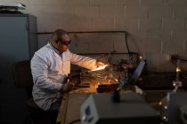 Side view of male worker using welding torch in glass factory — Stock Photo