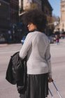 Frau mit Gepäcktasche läuft an einem sonnigen Tag in der Stadt — Stockfoto