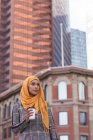 Pensativo hijab mujer tomando café en la ciudad - foto de stock