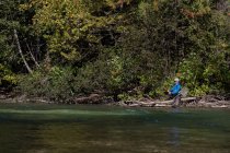Рыбак летит на рыбалку в реку в солнечный день — стоковое фото
