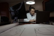 Інженер-робототехнік, що працює за столом на складі — стокове фото