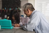 Grand-père et petite-fille dessin croquis sur table à manger à la maison — Photo de stock