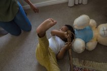 Piccolo ragazzo sdraiato sul pavimento in un soggiorno a casa — Foto stock