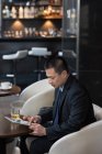 Homme d'affaires utilisant une tablette numérique sur le canapé de l'hôtel — Photo de stock