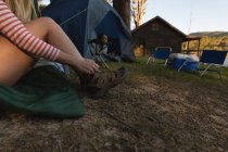 Primer plano de la mujer que usa zapatos en el camping - foto de stock