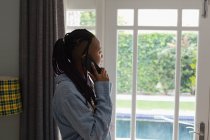 Женщина разговаривает по телефону в гостиной дома — стоковое фото