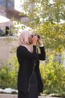 Hijab mulher clicando foto na câmera digital na varanda — Fotografia de Stock