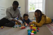 Família brincando com uma criança em uma sala de estar em casa — Fotografia de Stock