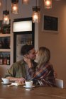 Романтична пара цілує один одного в кафе — стокове фото