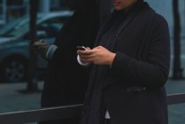 Seção média de mulher usando telefone celular na cidade — Fotografia de Stock