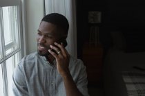 Людина говорити на мобільний телефон у вітальні на дому — стокове фото