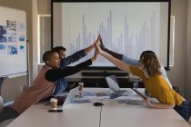 Executives giving hi five to each other in conference room at office — Stock Photo