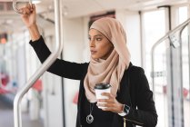 Hijab woman looking through window while travelling in train — Stock Photo
