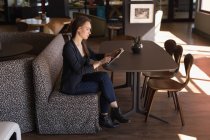 Бізнес-леді за допомогою цифровий планшетний в кафетерії в офісі — стокове фото