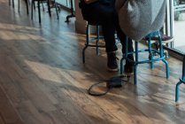 Sezione bassa di coppia seduta in un caffè con borsa caduta — Foto stock