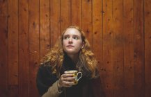Рыжая женщина пьет кофе в кафе — стоковое фото