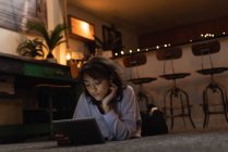 Красива жінка, використовуючи цифровий планшет на підлозі вдома — стокове фото