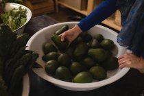 Frau pflückt Avocado aus Einkaufskorb im Supermarkt — Stockfoto