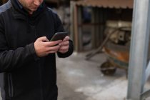Mann benutzt Handy in Gießerei-Werkstatt — Stockfoto