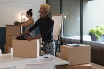 Бизнесмен разбирает картонную коробку в офисе — стоковое фото