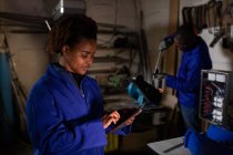 Trabajadora usando tableta digital en fábrica de vidrio - foto de stock