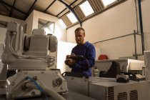 Ingénieurs robotiques opérant une machine robotique avec télécommande dans un entrepôt — Photo de stock