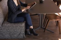 Geschäftsfrau nutzt digitales Tablet in Cafeteria im Büro — Stockfoto