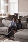 Großvater und Enkelin interagieren miteinander auf dem Sofa im heimischen Wohnzimmer — Stockfoto