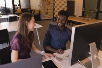 Geschäftskollegen interagieren am Schreibtisch im Büro miteinander — Stockfoto