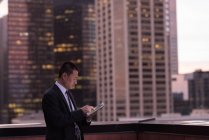 Uomo d'affari che utilizza tablet digitale in balcone in hotel — Foto stock