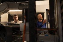 Ingenieros robóticos atentos trabajando en el almacén - foto de stock