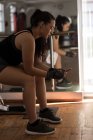 Vista lateral do boxeador feminino usando telefone celular no estúdio de fitness — Fotografia de Stock